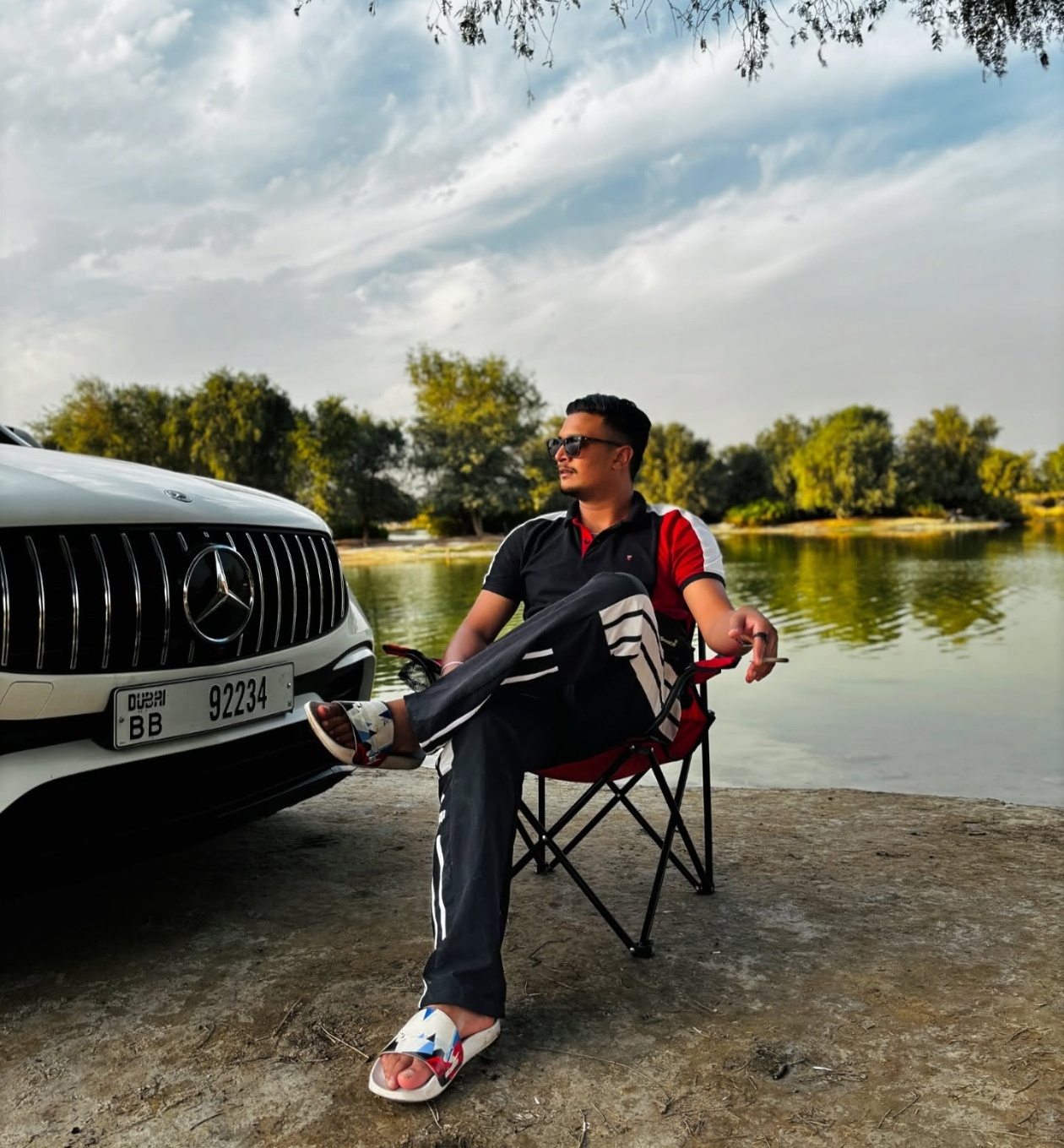 Afshan Afsal beside a lake in the UAE next to a Mercedes